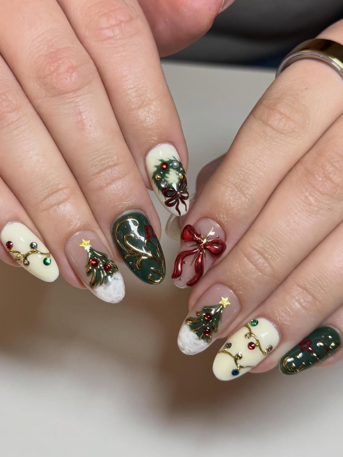 Christmas themed nail art with tiny trees and red bows on almond nails