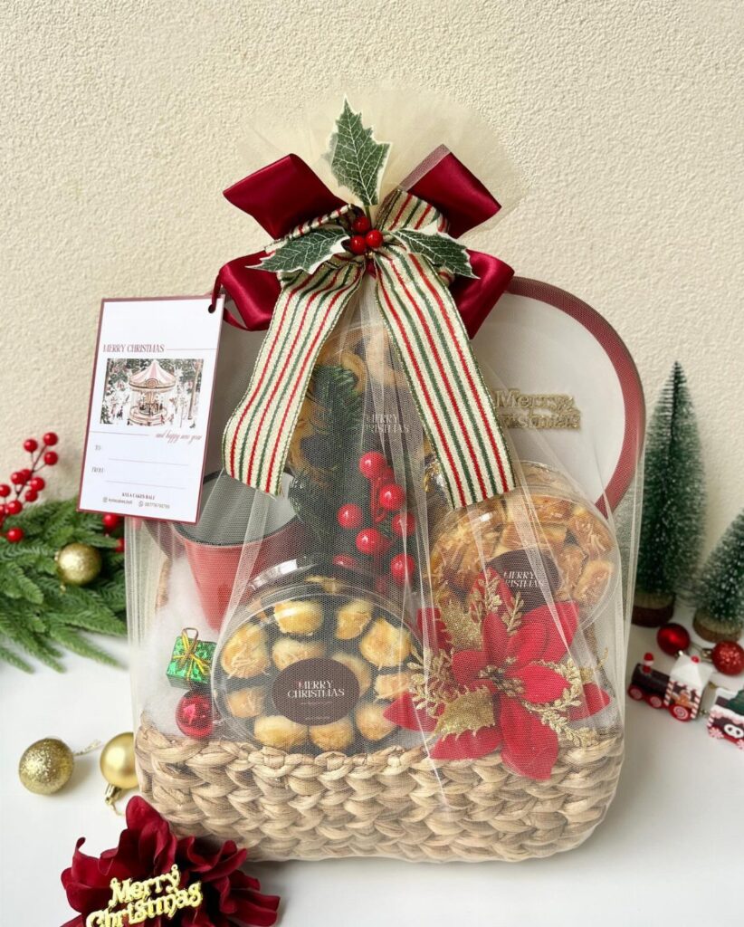 Gourmet food hamper in a woven basket wrapped in cellophane with a red bow.
