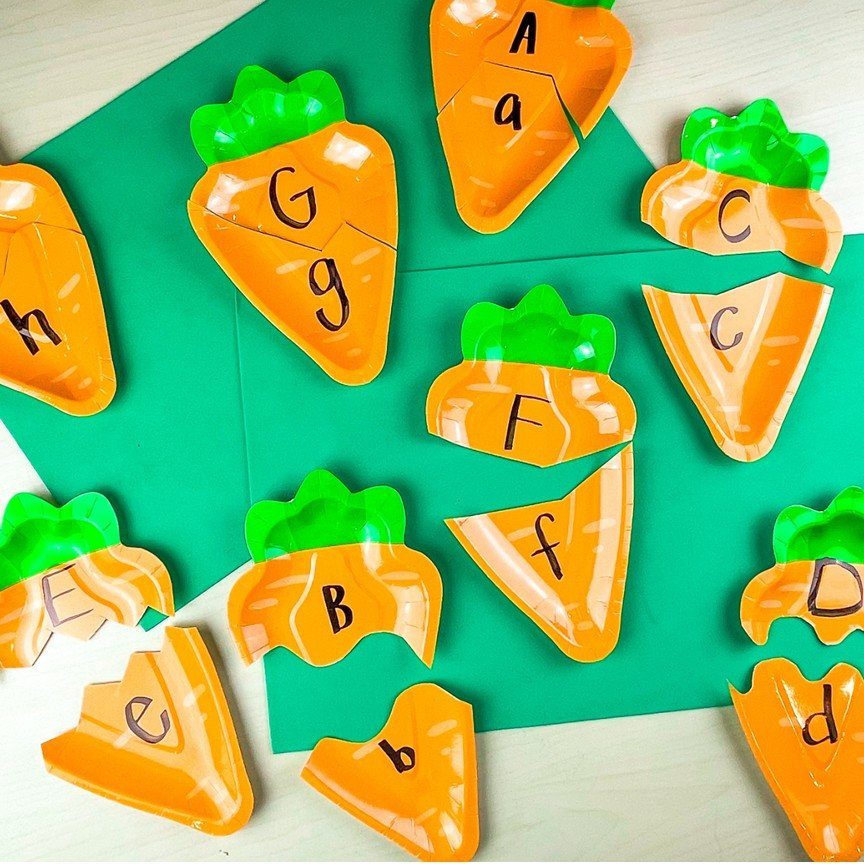 Carrot-shaped alphabet puzzles with matching uppercase and lowercase letters on green paper.