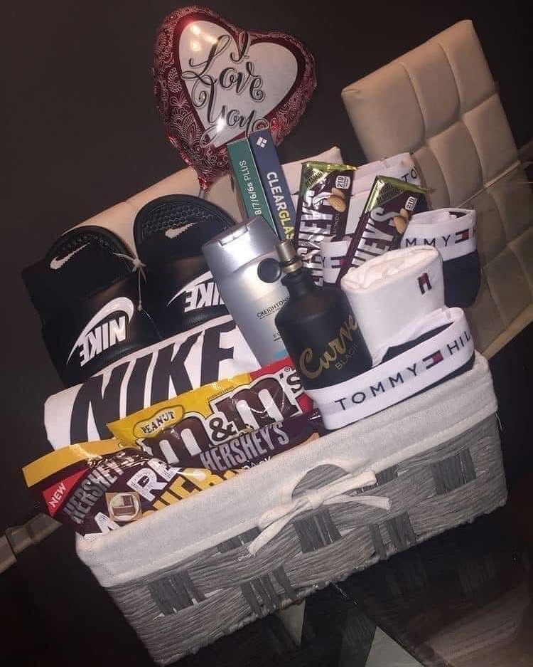 Gift basket for boyfriend with Nike slides, chocolates, and a heart balloon.
