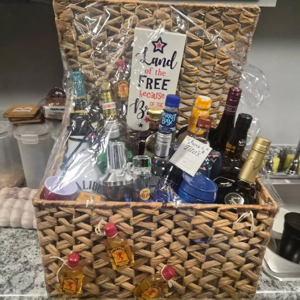 Wicker gift basket filled with various liquor bottles and a patriotic sign.