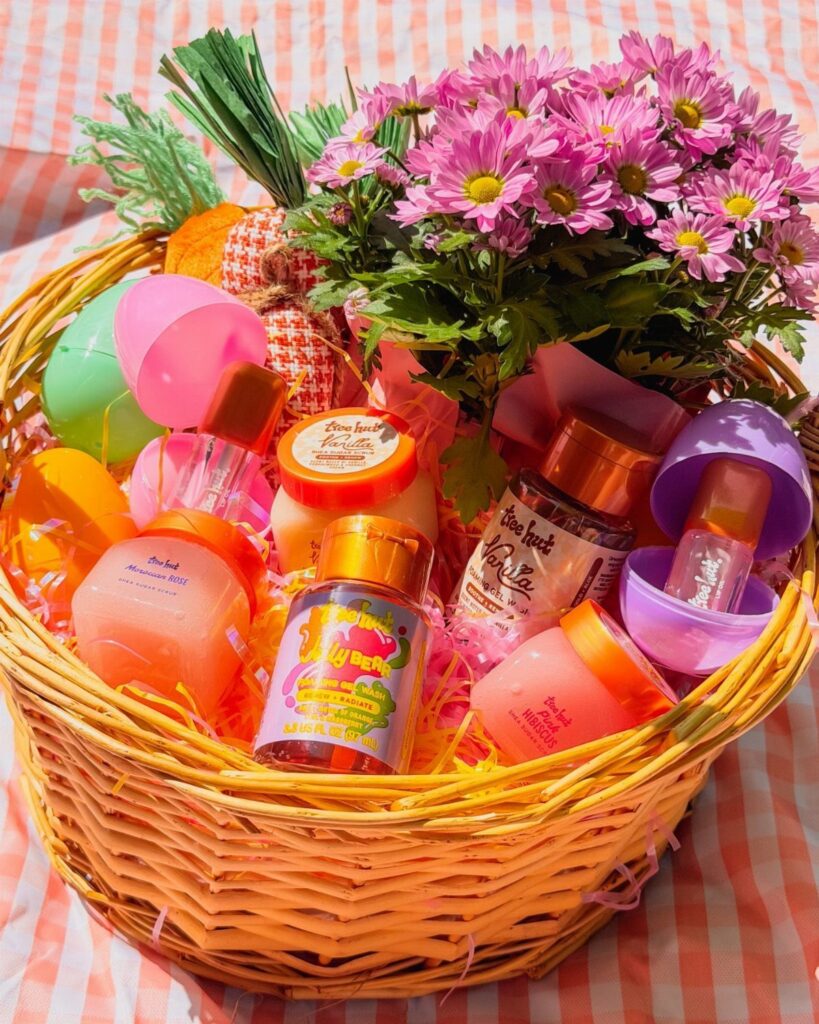 Wicker Easter basket filled with beauty products, colorful eggs, and pink flowers.