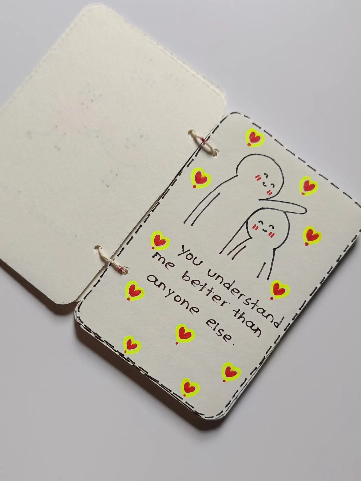 Handmade card with a drawing of two figures hugging and a heartfelt message.