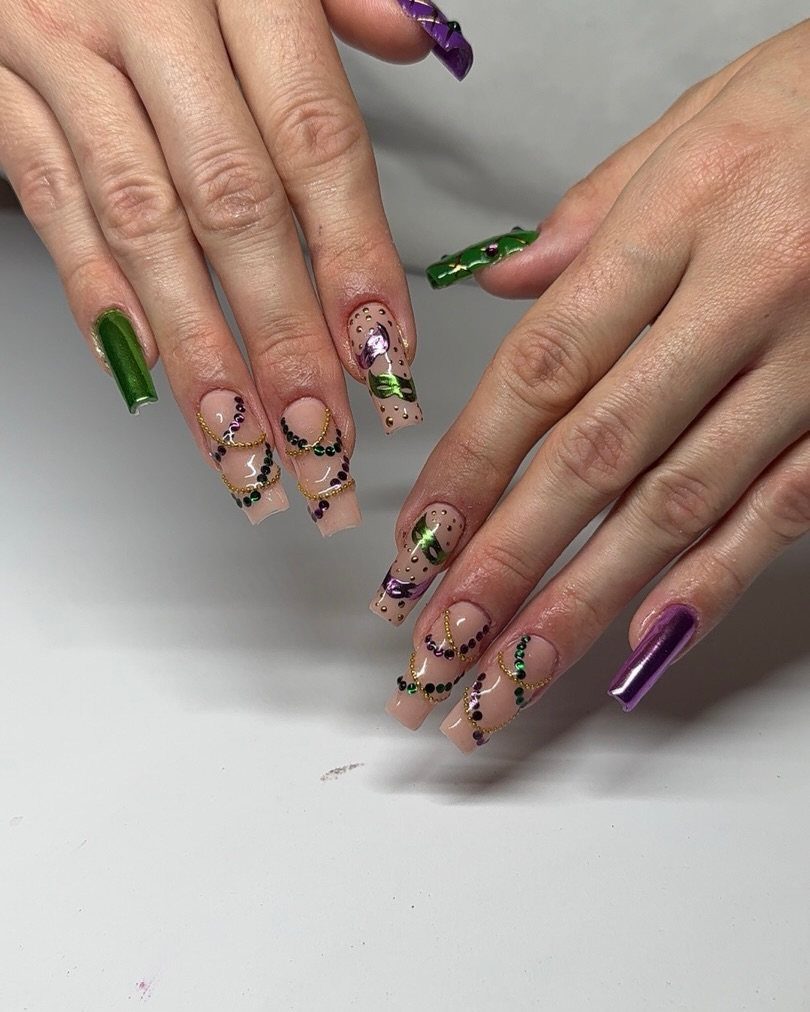 Long coffin nails with purple, green, and gold glitter Mardi Gras designs.