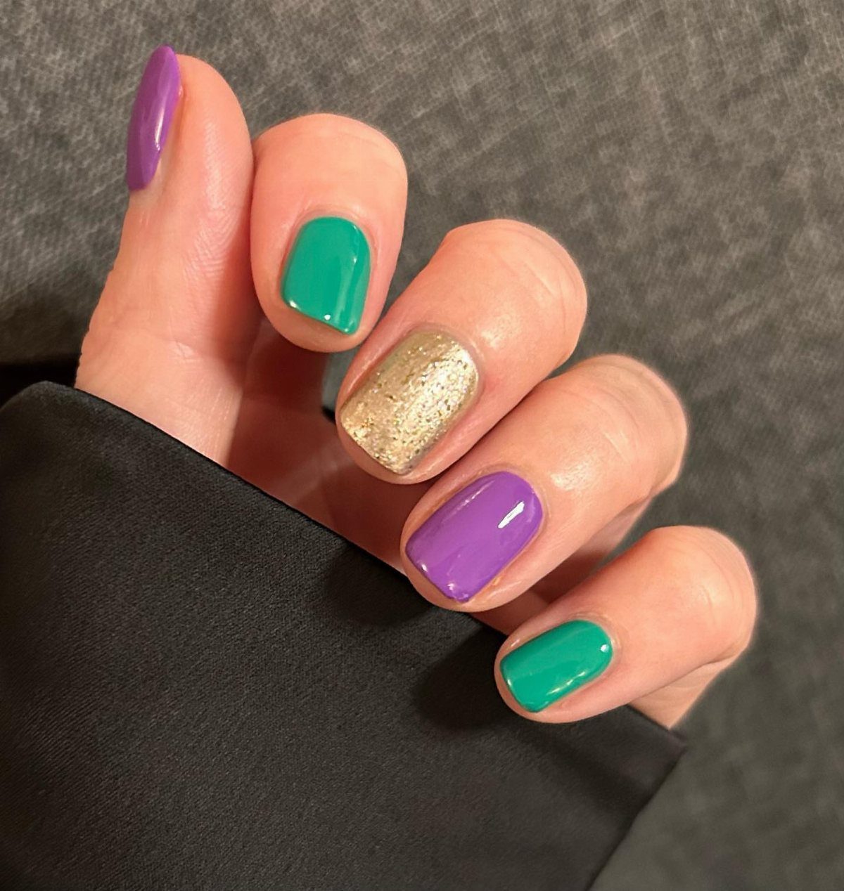 Fingernails painted in purple, green, and gold glitter for Mardi Gras theme.