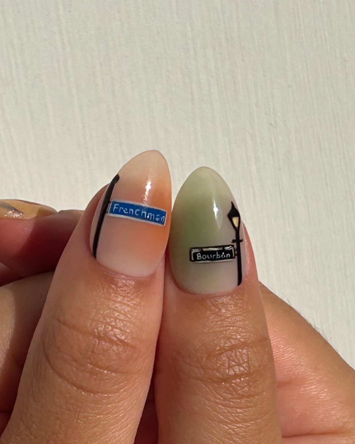 Nail art featuring New Orleans street signs for Frenchman and Bourbon streets.