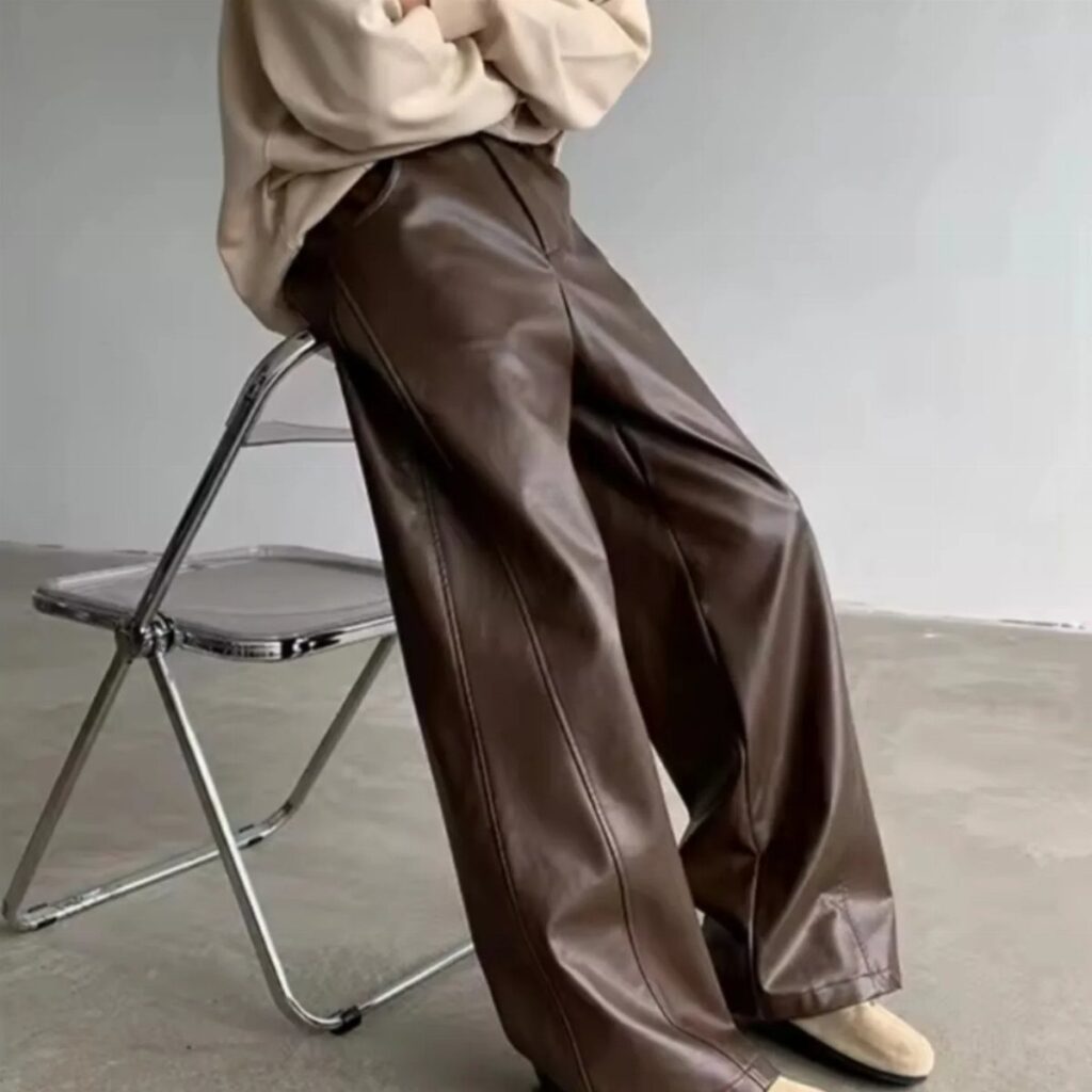 Brown faux leather wide-leg pants paired with a cream oversized cozy sweater.