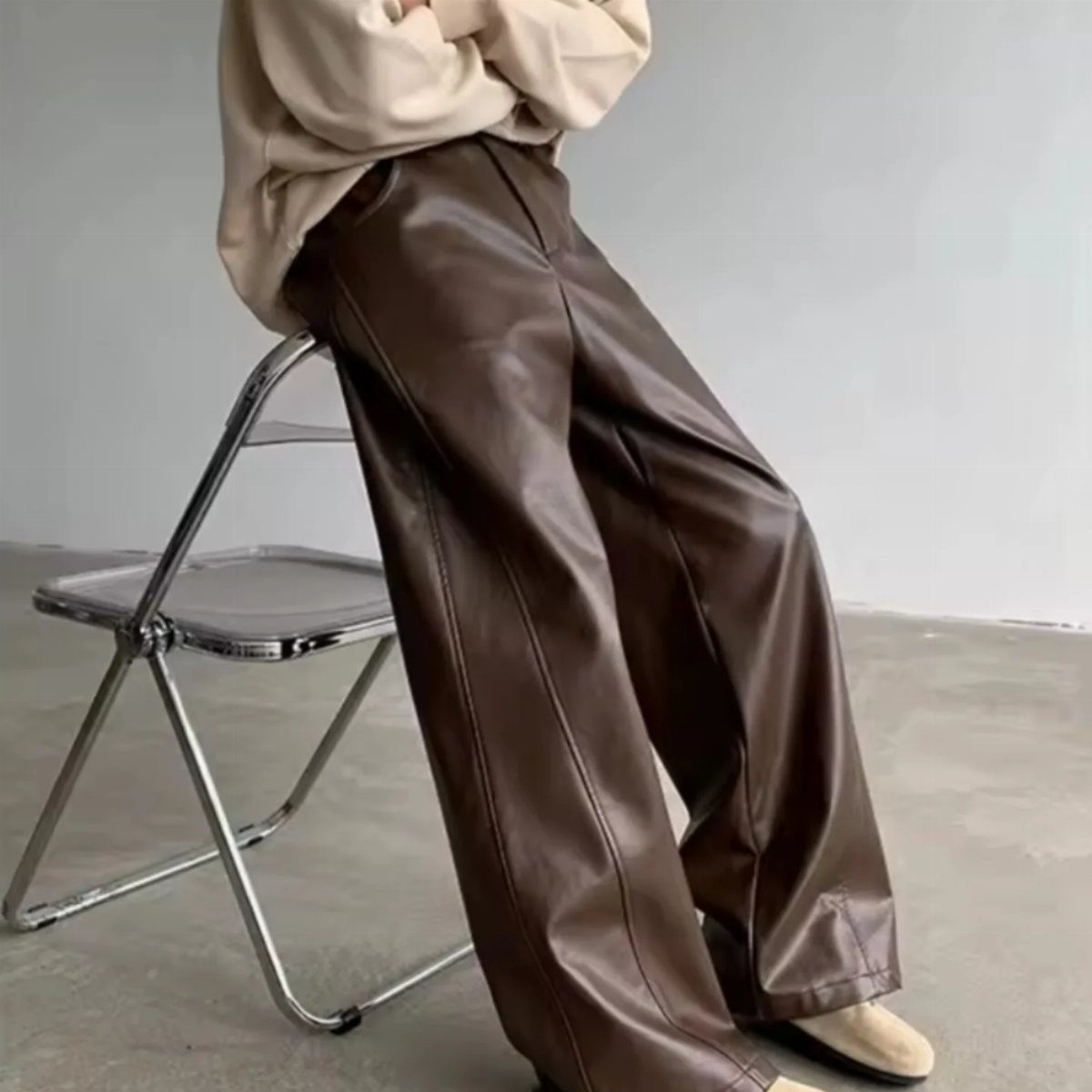 Brown faux leather wide-leg pants paired with a cream oversized cozy sweater.