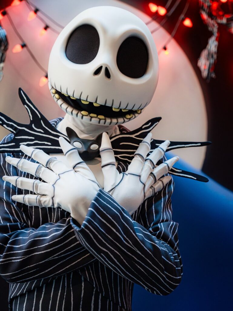 Person in a Jack Skellington costume with a skull mask and pinstriped suit.