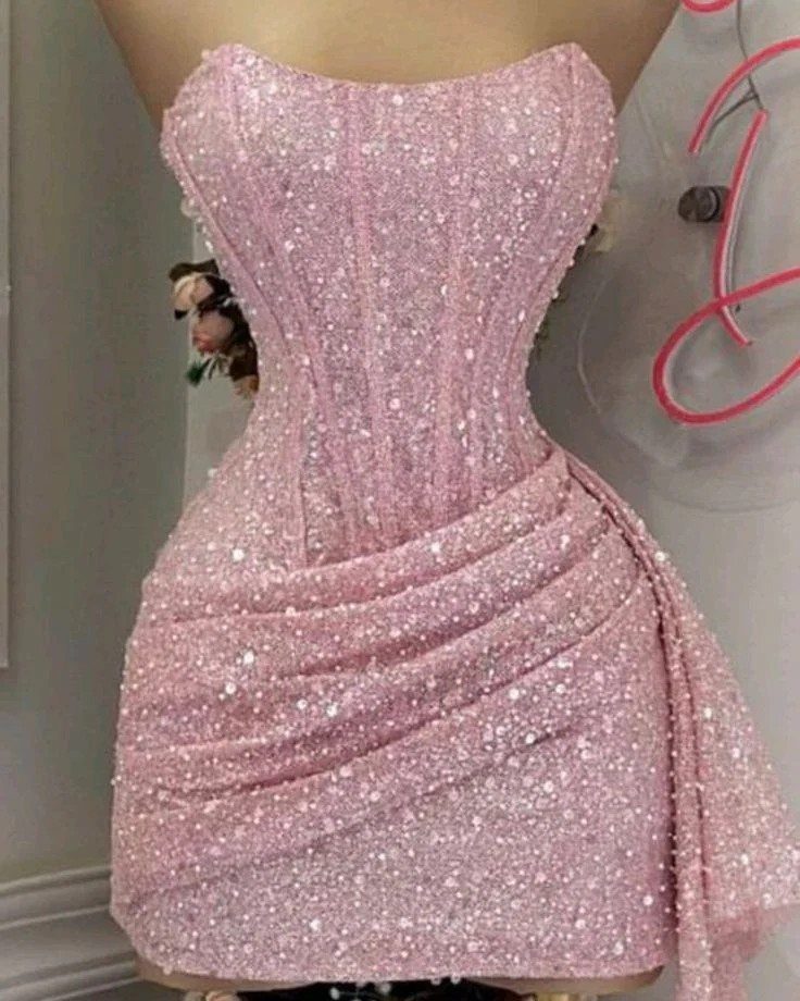 Pink sequined strapless mini dress with a corset bodice and draped skirt.